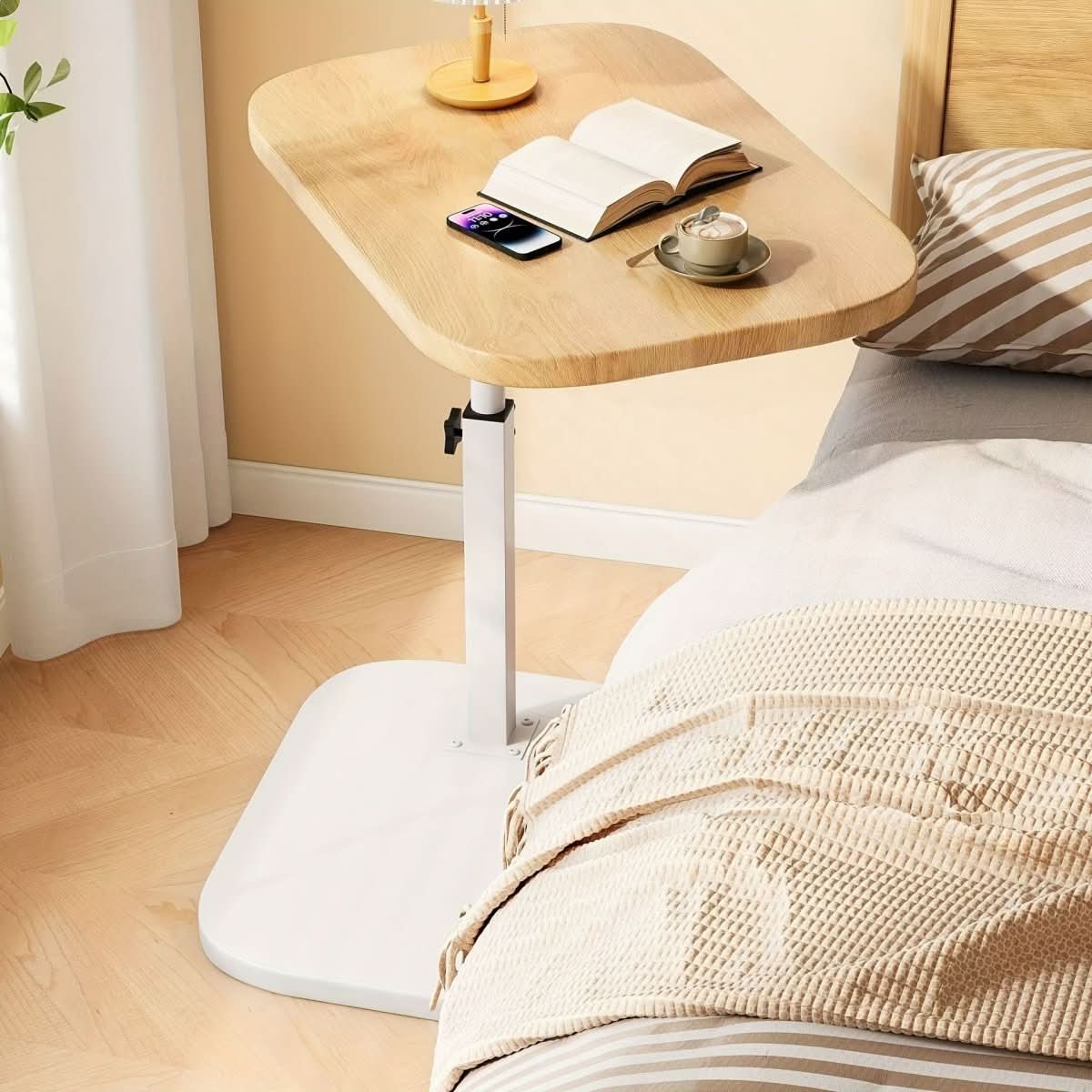 Licht tafelblad met witte voet naast een bed