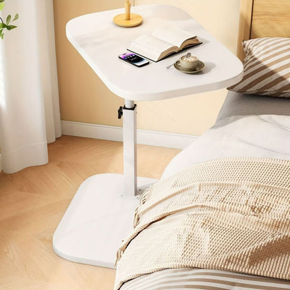 Wit tafelblad met witte voet naast een bed
