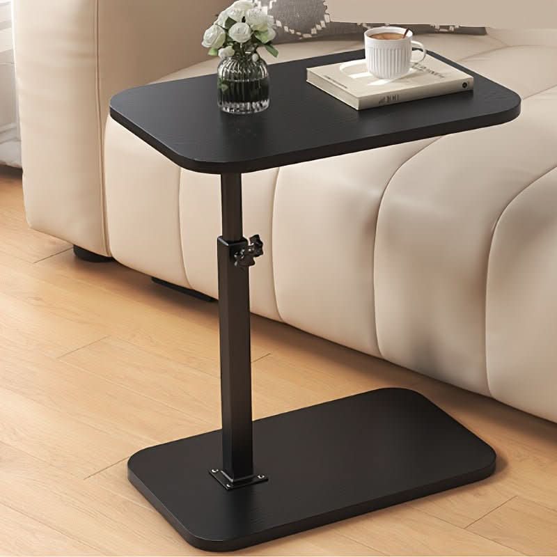 Zwarte bijzettafel naast een bank met kopje en vaasje