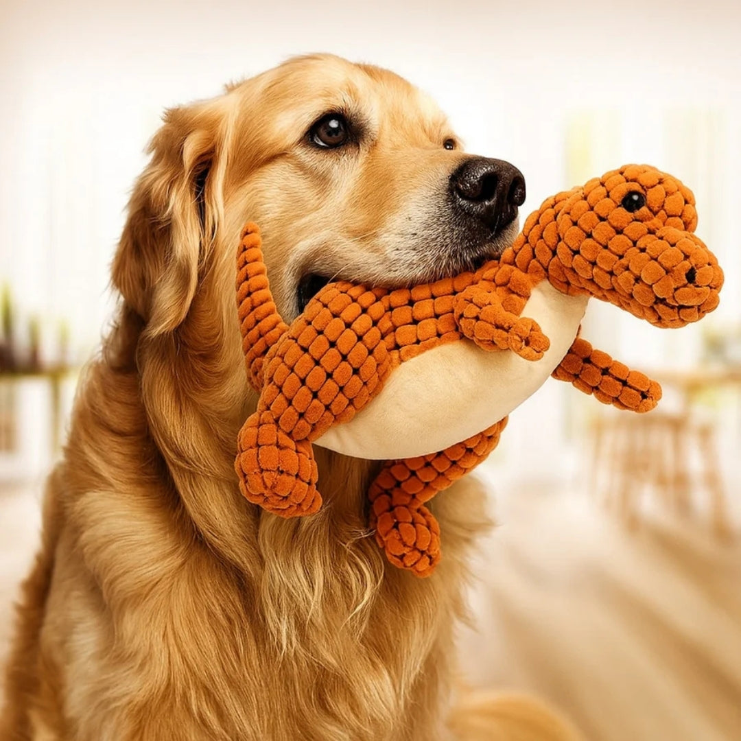 Golden retriever met een oranje pluche dinosaurus