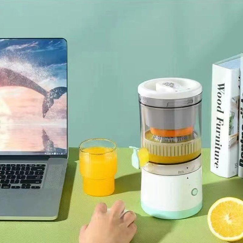 Citruspers en glas sap naast een laptop