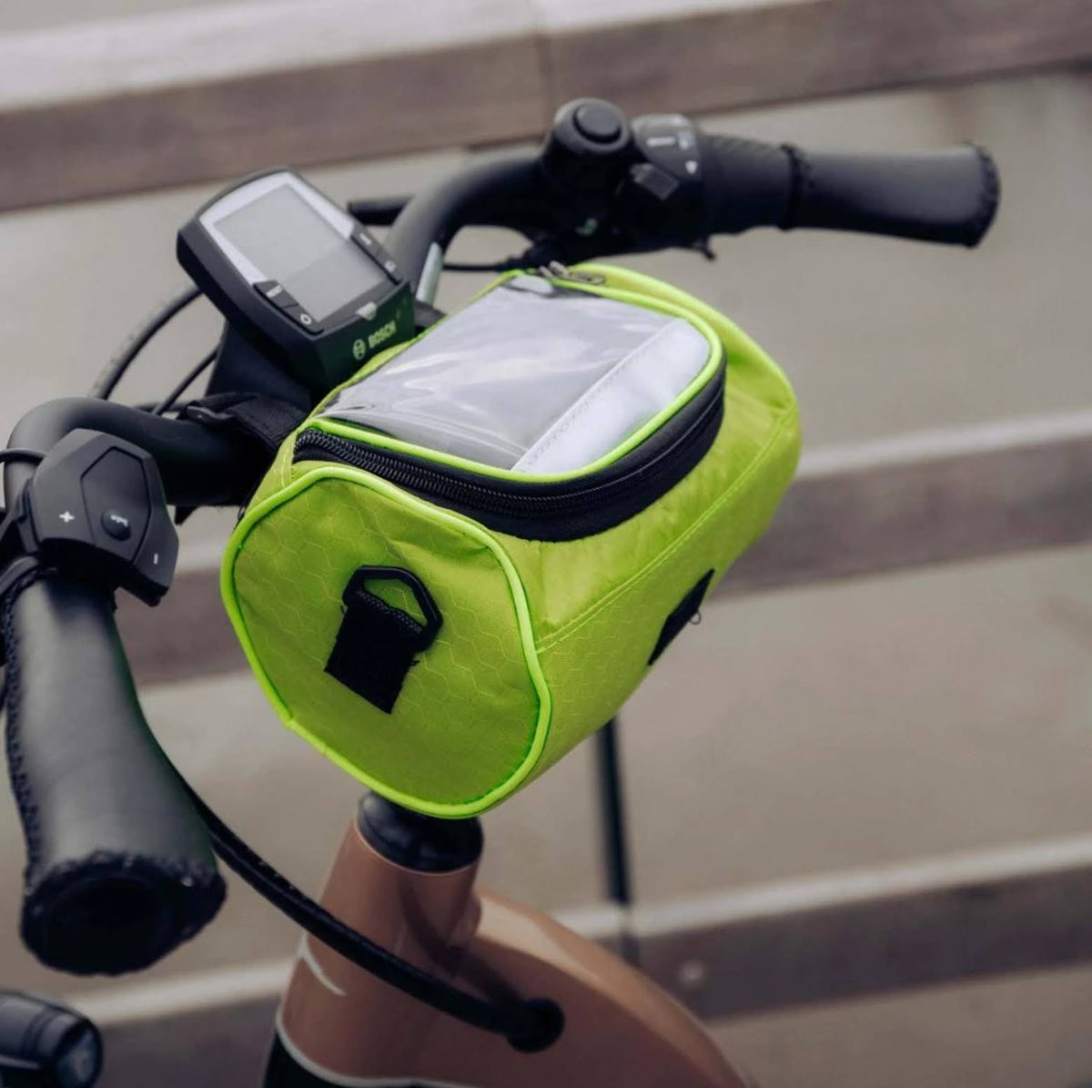 Groene fietstas met telefoonvenster aan een stuur