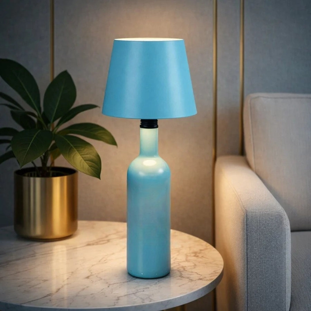 Blauwe fleslamp op een lichtblauwe fles naast een plant