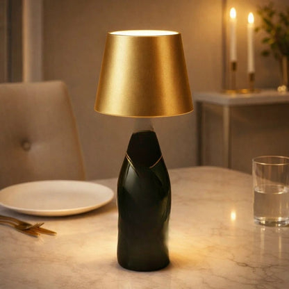 Goudkleurige fleslamp op een donkere fles naast een bord