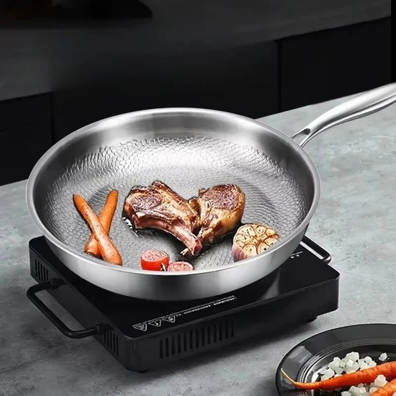 Koekenpan met vlees en groenten op een kookplaat