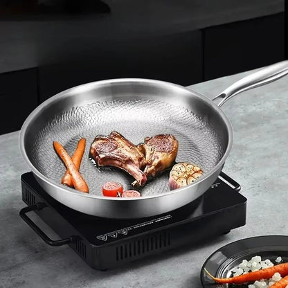 Koekenpan met vlees en groenten op een kookplaat