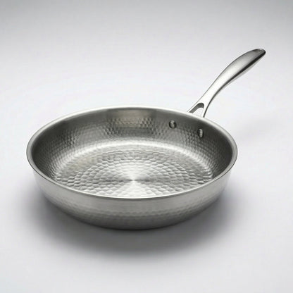 Zilverkleurige koekenpan met metalen steel schuin van boven