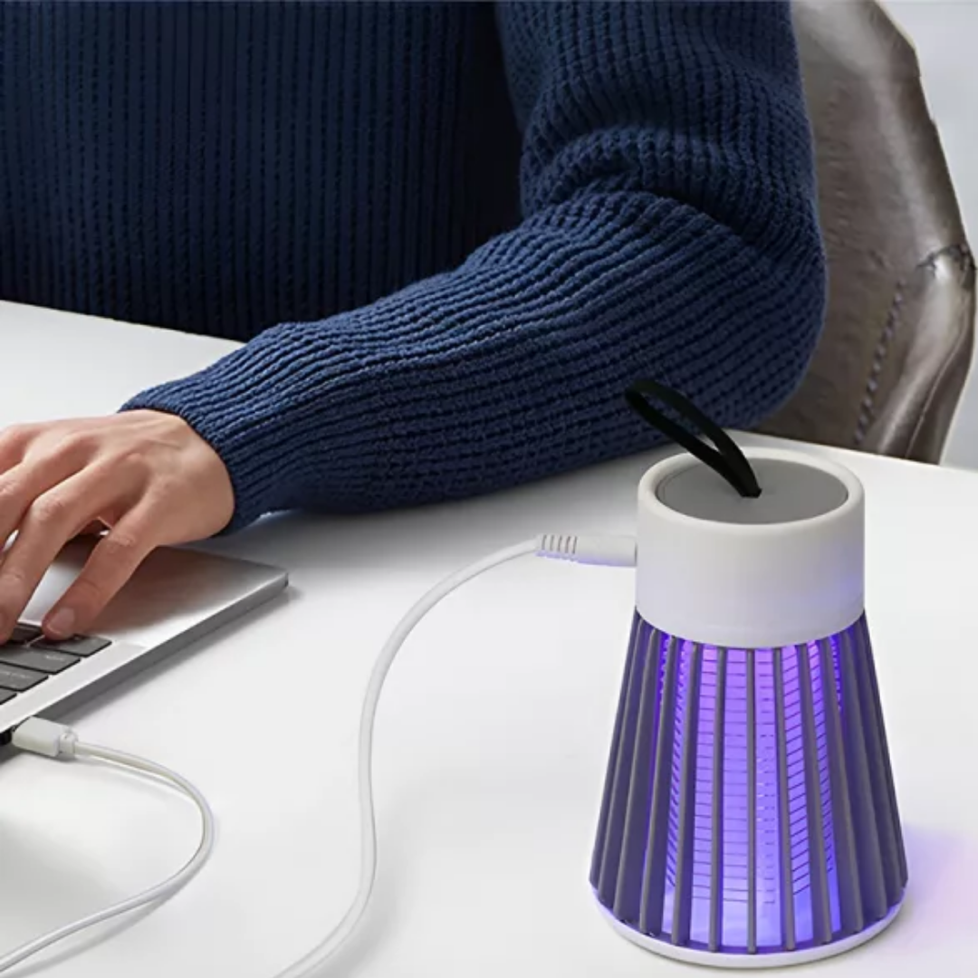 Muggenlamp met laadkabel op een bureau bij een laptop