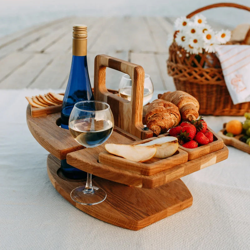 Houten picknicktafel met fles en glazen naast een picknickmand