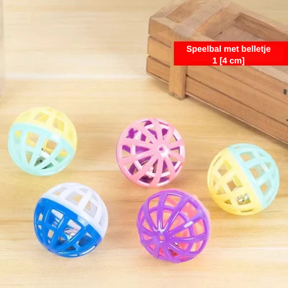 Gekleurde speelballen met belletjes op een houten vloer