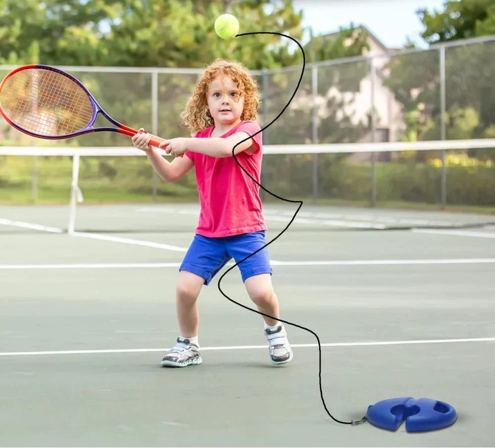 Kind oefent tennis met een bal aan een koord en een blauwe basis