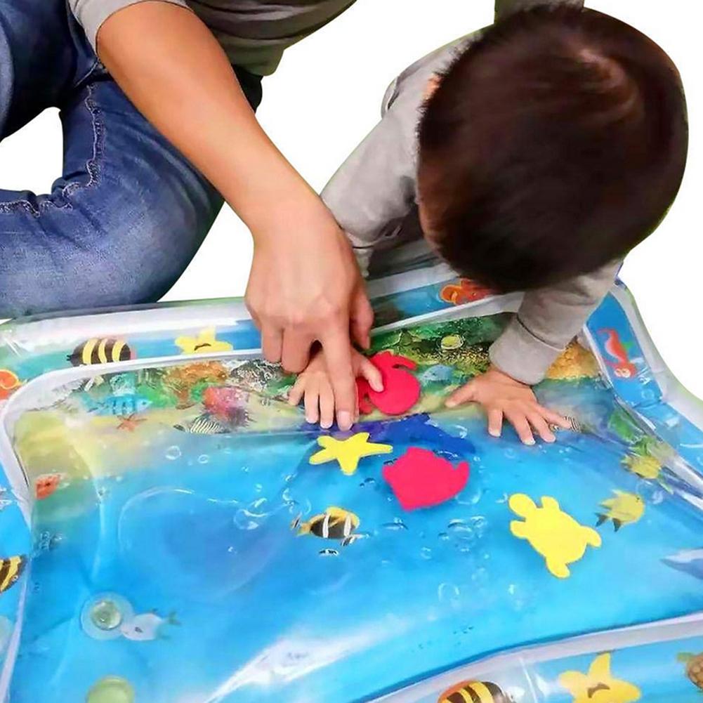 Volwassene en kind kijken naar zeediertjes in de waterspeelmat